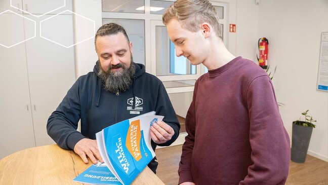 Zwei Personen schauen in ein Buch